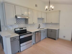 Two-tone gray and white shaker kitchen remodel in The Colony, TX with quartz countertops and subway tile backsplash.